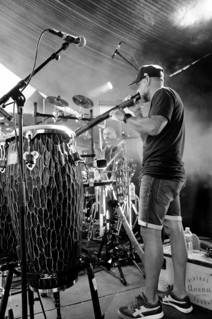 Cyril Bach sur scène avec les congas, les percussions et le didgeridoo, percussionniste de LITTLEBIG6STER.