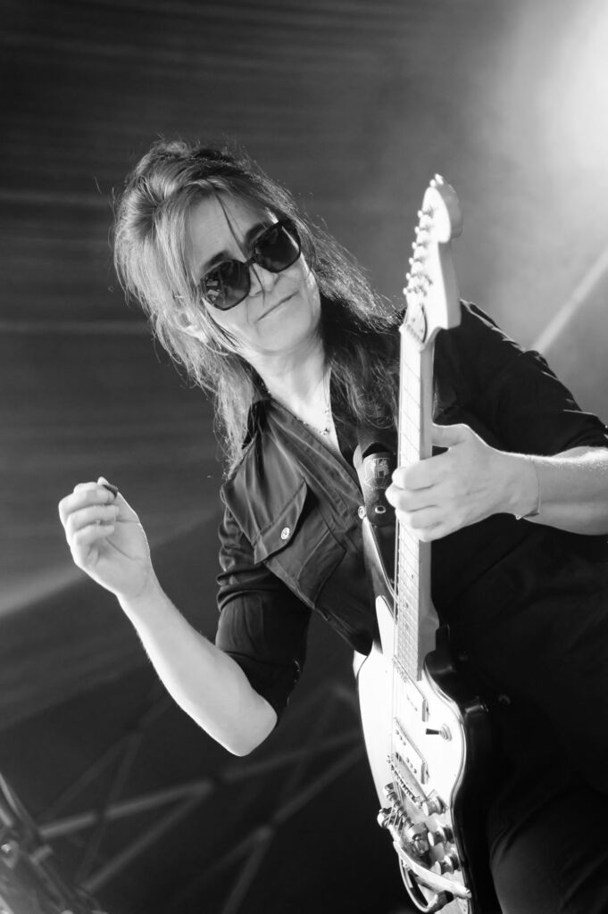 Virginie Pinon sur scène avec sa guitare, fondatrice, chanteuse, guitariste et auteure-compositrice de LITTLEBIG6STER.